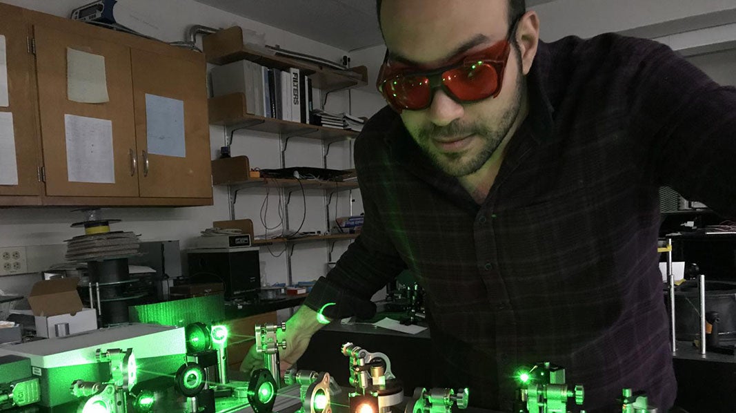 Student wearing tinted safety goggles working in a lab