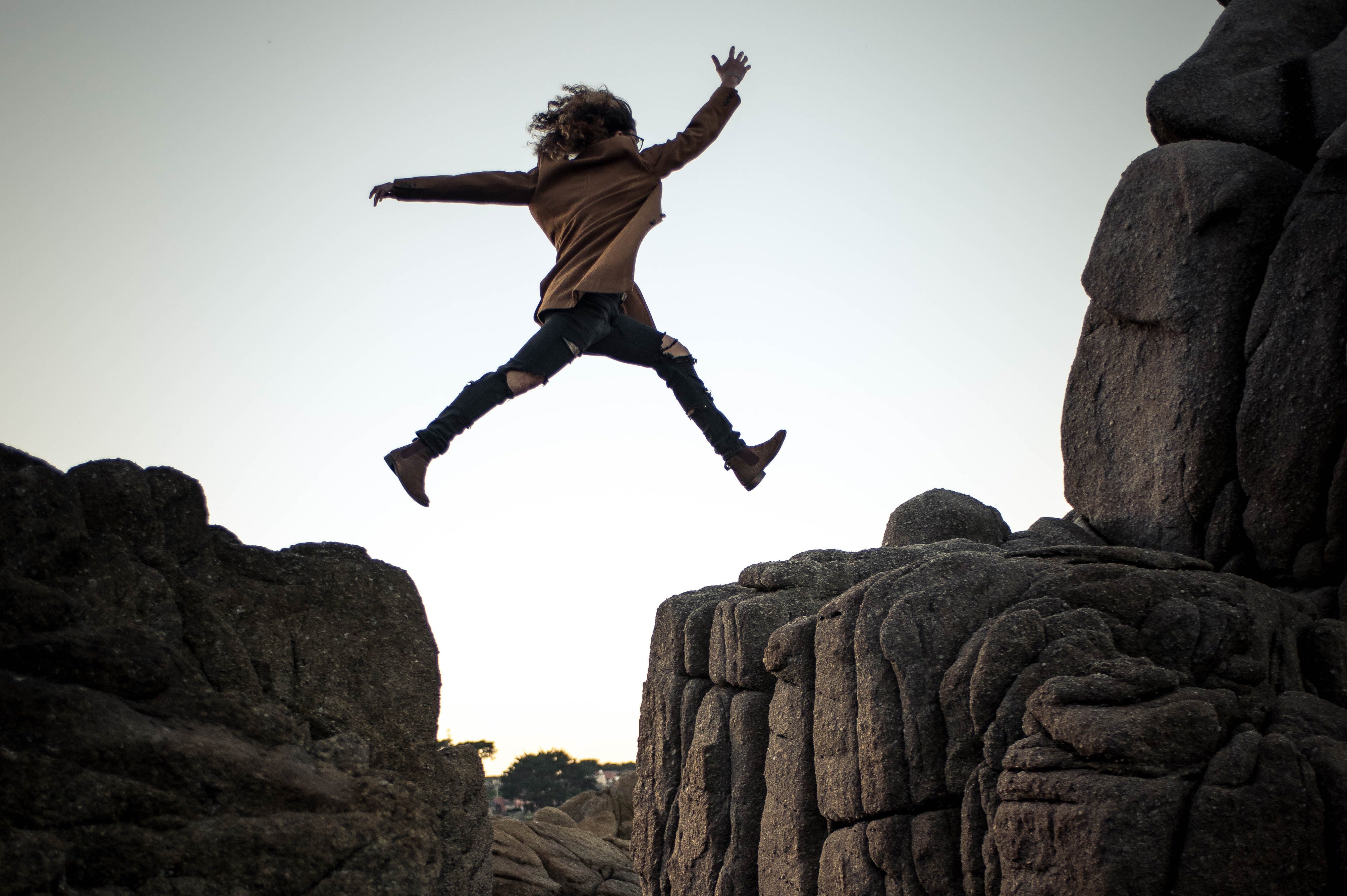 Person jumping between two cliff faces