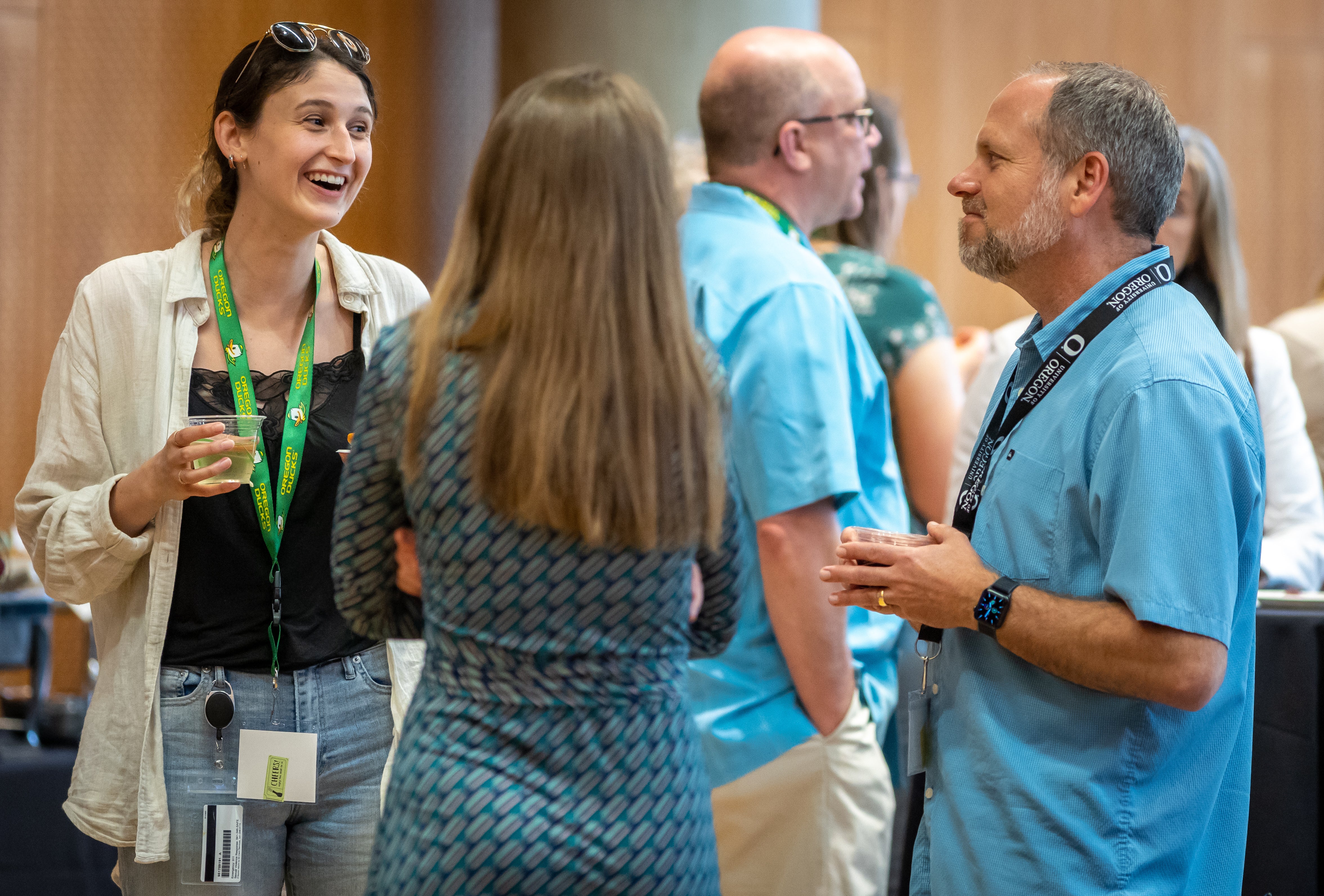 Three individuals are shown chatting at a reception. 