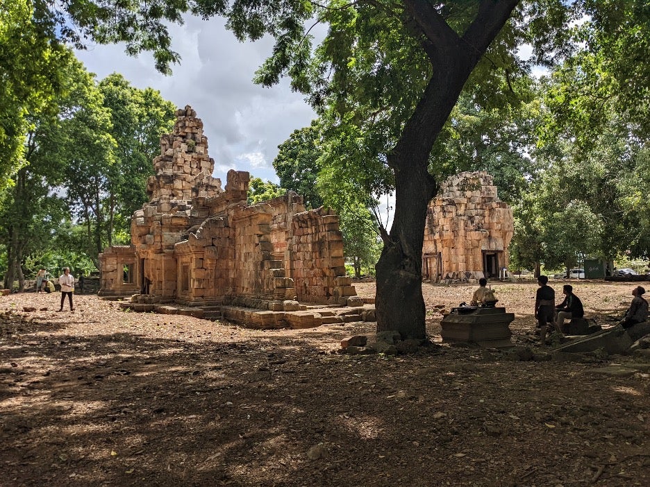 People stand around the ruins of the Baset temple.