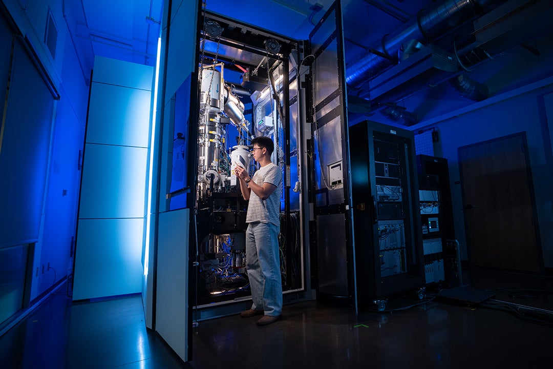 Man standing in front of the Transmission Electron Microscopy at the CAMCOR facility.