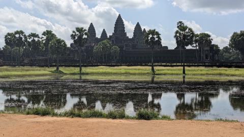 The temple of Angkor Wat is seen from across a body of water.