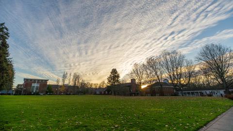 The sun sets behind the College of Education on a clear winter day.