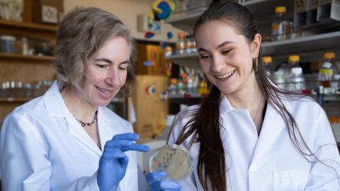 Two female scientists in a lab smiling.