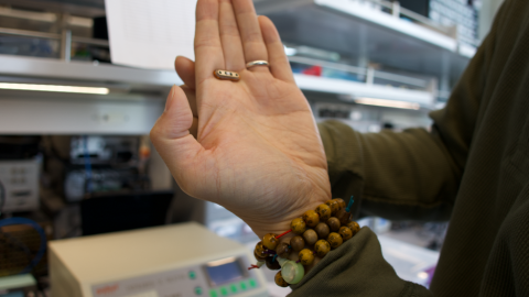 Man holds a small metal sensor in between his fingers to demonstrate the technology.