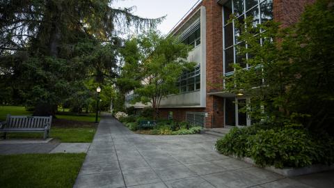A concrete walkway leads past Allen Hall on the University of Oregon campus.