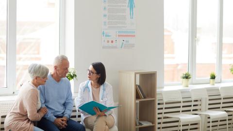 A doctor talking to an older man and woman.