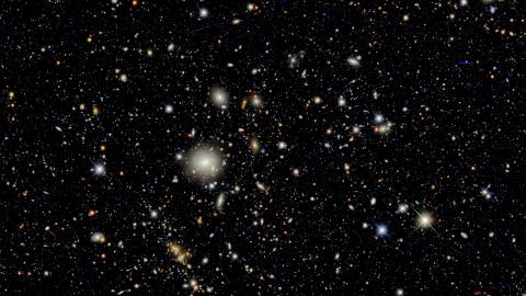 Distant galaxies look like blobs of light in the darkness of space.