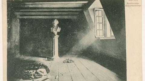 A sunbeam comes in through a window and falls on the base of a bust of Beethoven.