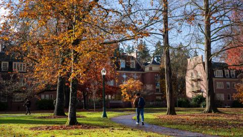 Student walks on campus on a sunny day in the fall