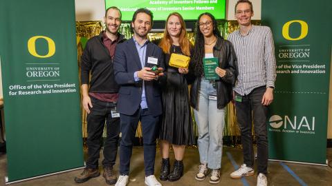 Five people stand with awards at the Gold Egg Award event