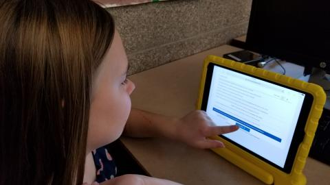 A child takes an assessment on a tablet.