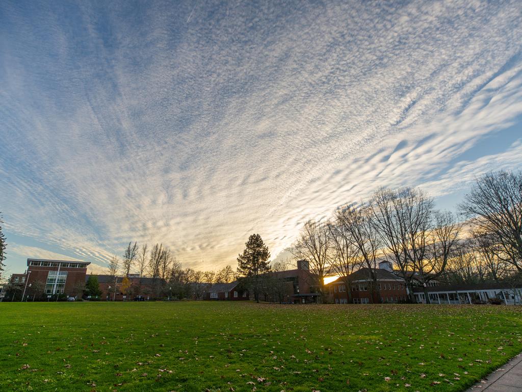 The sun sets behind the College of Education on a clear winter day.