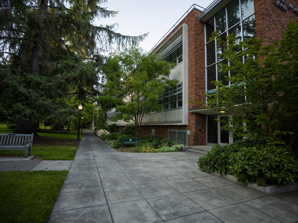 A concrete walkway leads past Allen Hall on the University of Oregon campus.