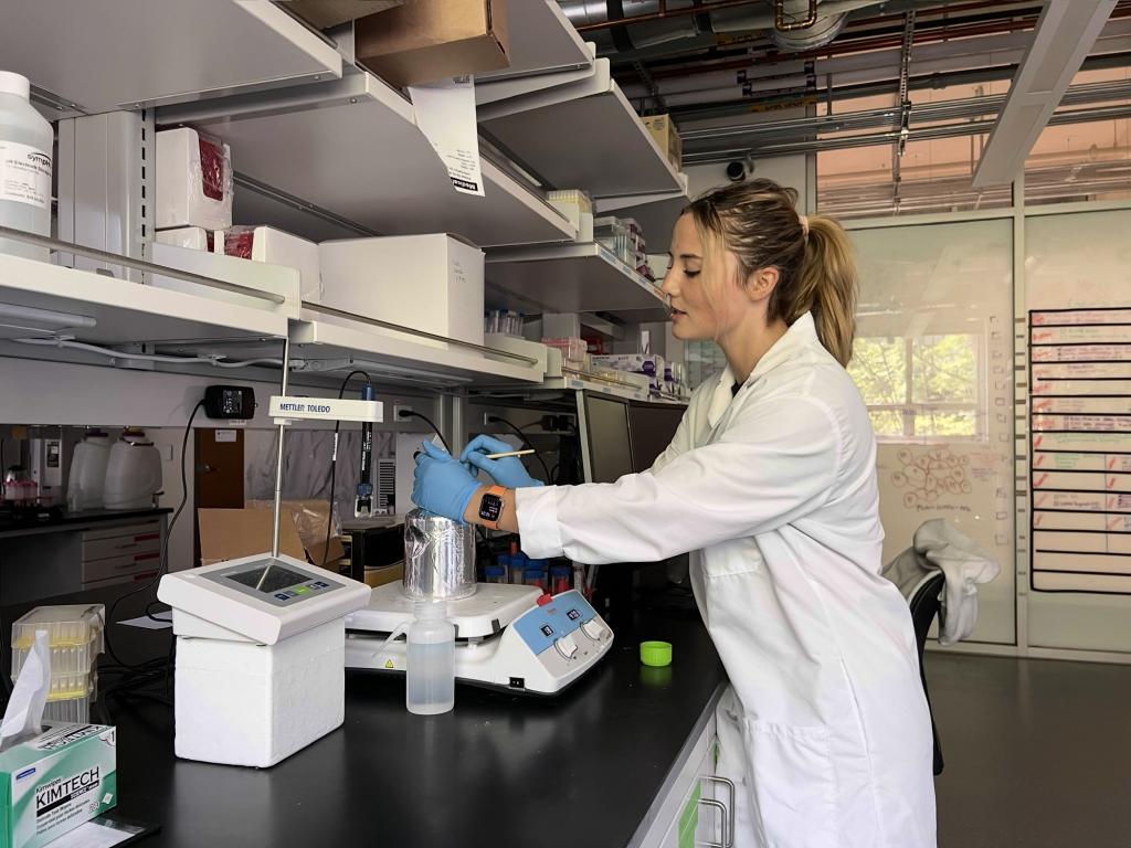 Tallula Wynia leans over a scale in a laboratory. 