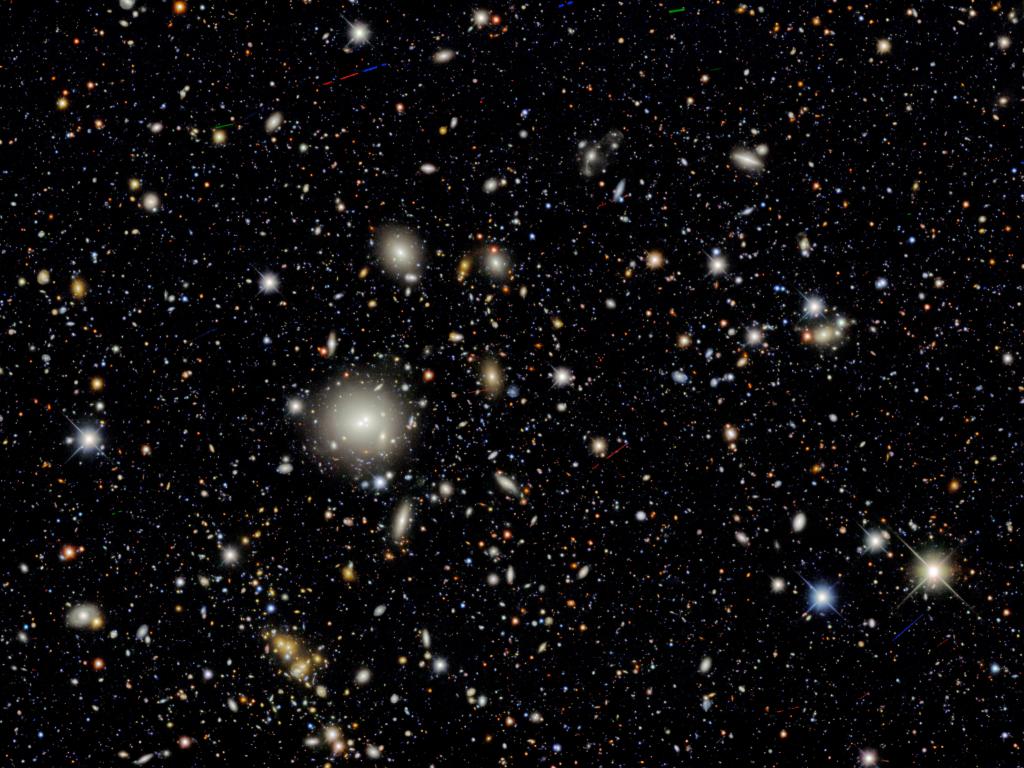 Distant galaxies look like blobs of light in the darkness of space.