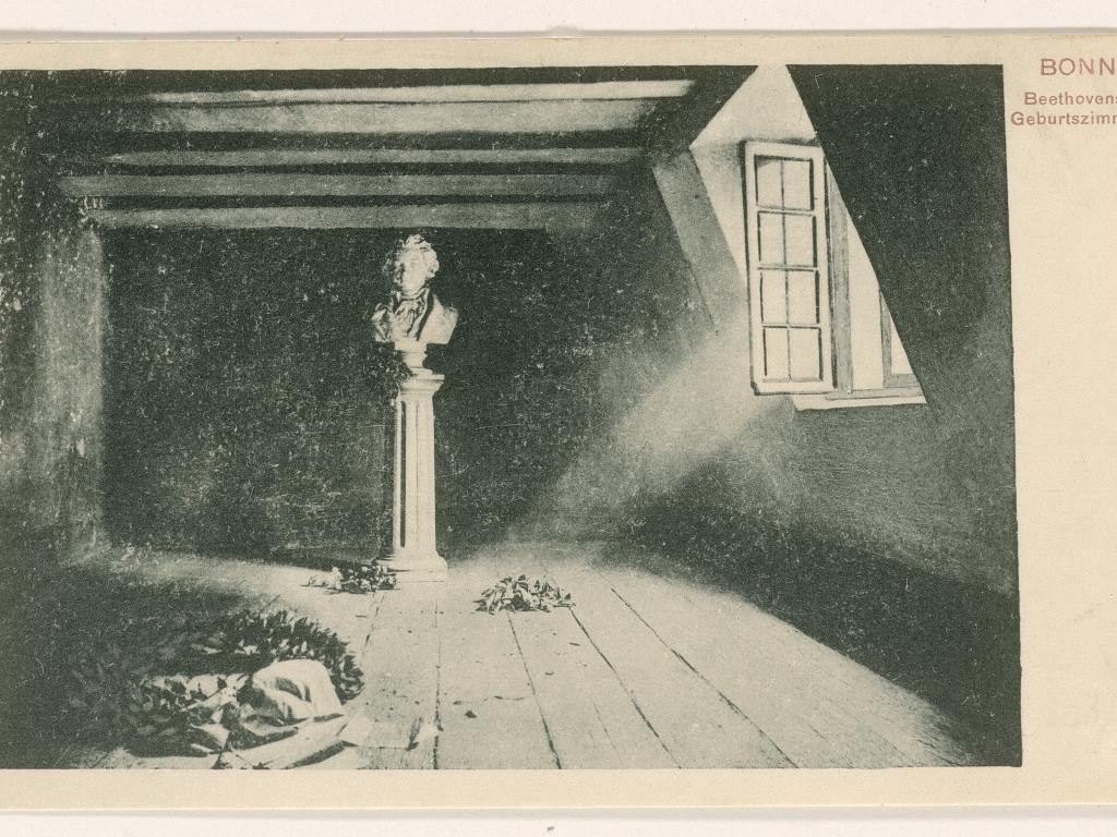 A sunbeam comes in through a window and falls on the base of a bust of Beethoven.