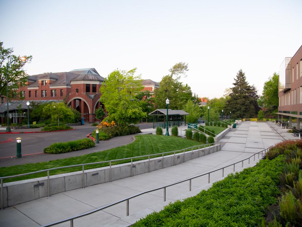 a sidewalk and a street lined with brick buildings