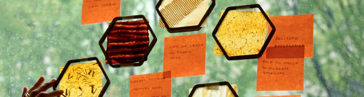 Multiple handwritten notes are stuck to a window alongside samples of translucent bio-materials.