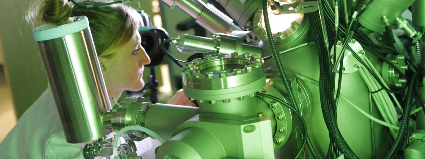 Woman works with a large machine that has many cables attached to it.