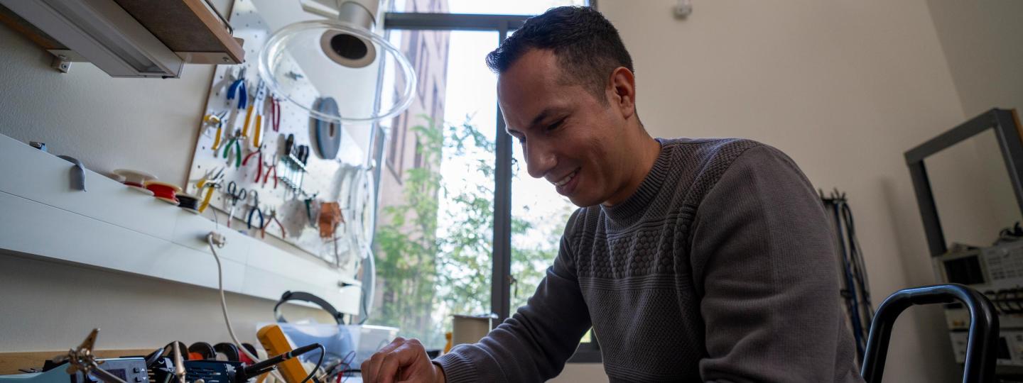 A person works on a small piece of equipment in the Lewis Center for Neuroimaging.