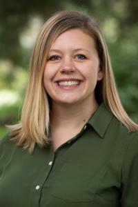 Kate Petcosky-Kulkarni headshot against green outdoor backdrop