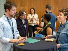 Attendees talking at high-top table during WIN reception.