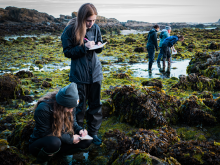 Maddy Rusk and Katie Richardson, both seniors in the marine biology program, take notes to catalogue their finds during tidepooling.