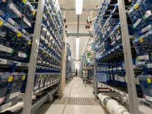Rows of fish tanks line both sides of a walkway in the aquatic animal care facilities.