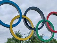 The Olympic rings against a cloudy sky.