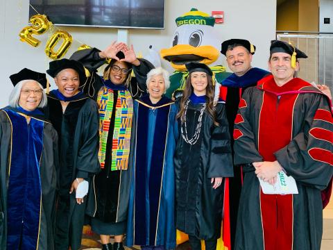 A group of people in academic regalia pose for a portrait.