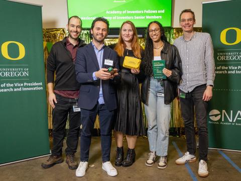 Five people stand with awards at the Gold Egg Award event.