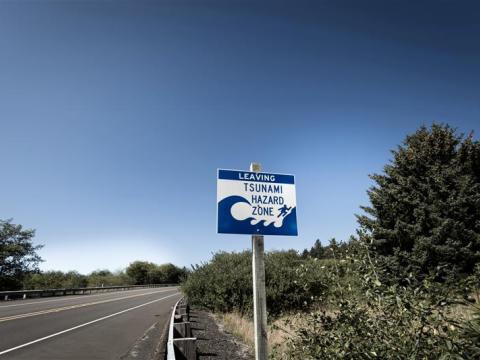 A sign on the side of a road indicating that it is a tsunami hazard zone.