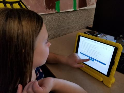 A child takes an assessment on a tablet.