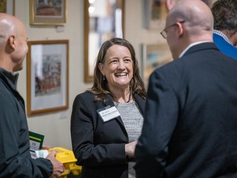 Christine Dixon Thiesing chats with attendees at a reception.