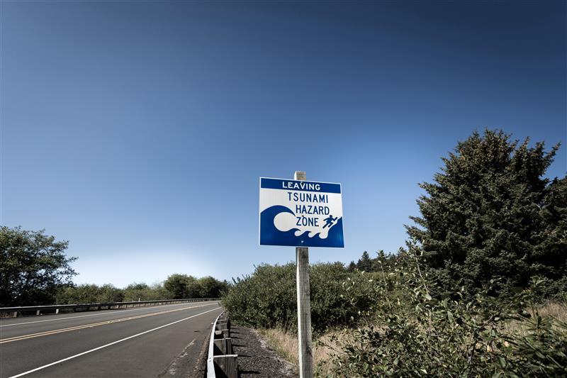 A sign on the side of a road indicating that it is a tsunami hazard zone.