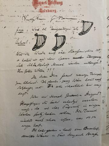 A page with handwritten notes and crude drawings of harps.